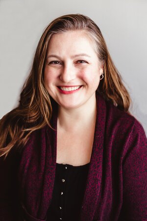 Dr. McDuffie smiles in a burgundy cardigan against a white background. 