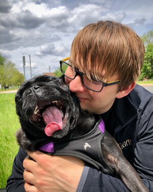 Ryan smiles with his pug.